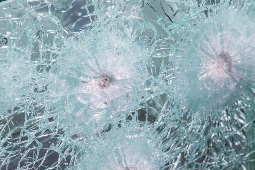 Bullet proof window with several bullets lodged in the shattered glass