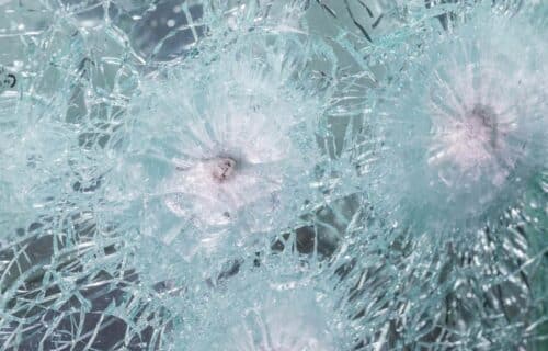 Bullet proof window with several bullets lodged in the shattered glass